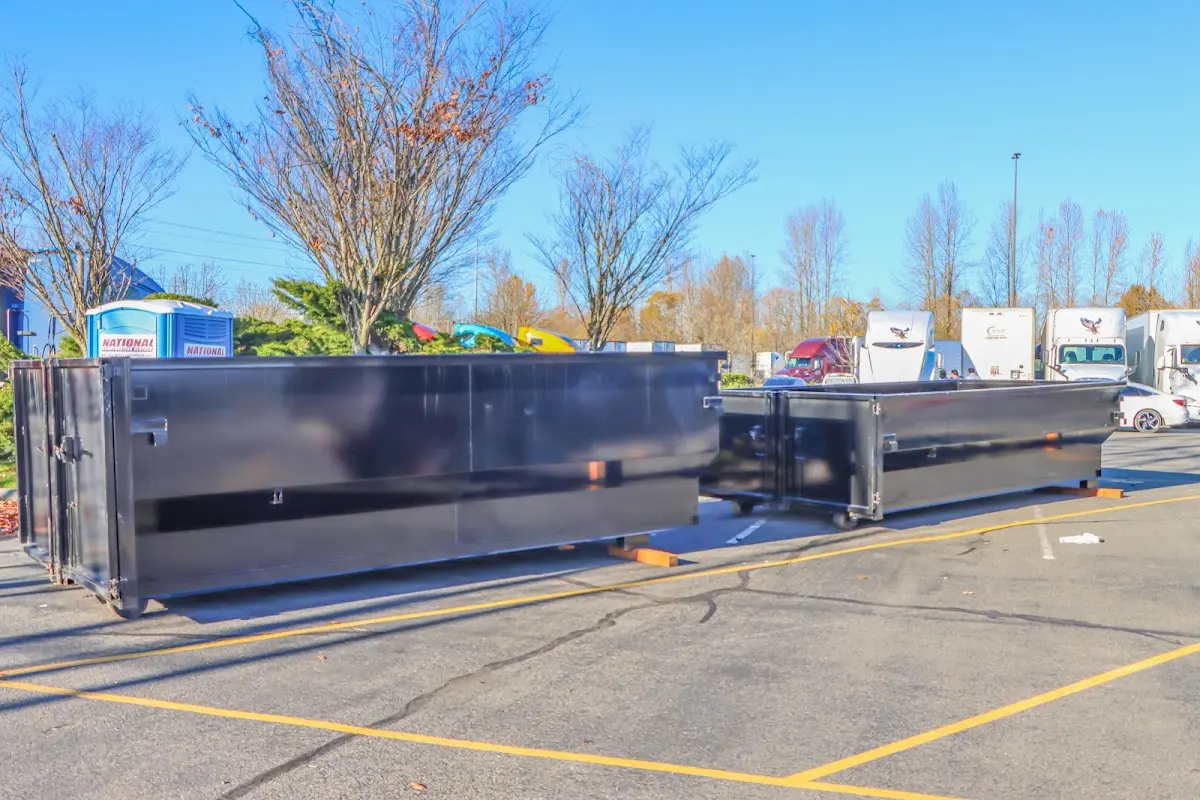 Professional dumpster rental service with roll-off container on residential driveway in Wharton